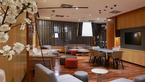 Un espace de détente moderne avec des canapés, des poufs et une table à manger.