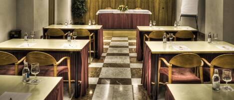 A conference room with checkered flooring, wooden chairs, and tables set for meetings.