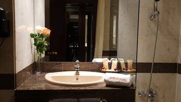 Une salle de bain avec un lavabo, un miroir et une douche.
