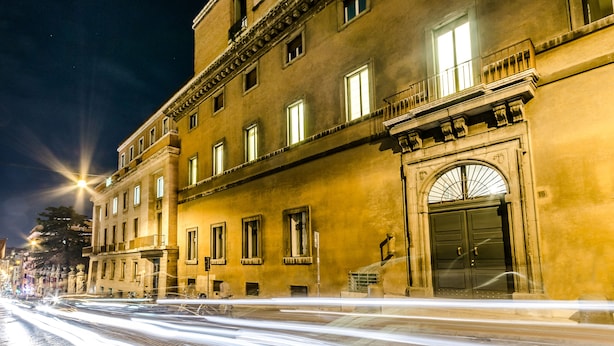A historic building with multiple stories, large windows, and a prominent entrance with a decorative archway. - Luxury Rooms H 2000 Roma (Rome)