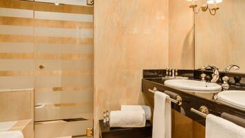 A modern bathroom with a glass shower enclosure, a vanity with a sink, and a large mirror.