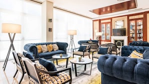 A spacious living room with a fireplace, large windows, and a collection of bookshelves. - Eurostars Gran Hotel Santiago (Santiago de Compostela)