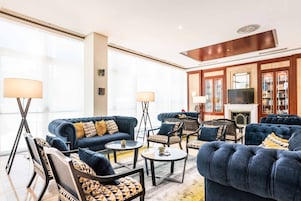 Un salón amplio con chimenea, ventanas grandes y una colección de estanterías.