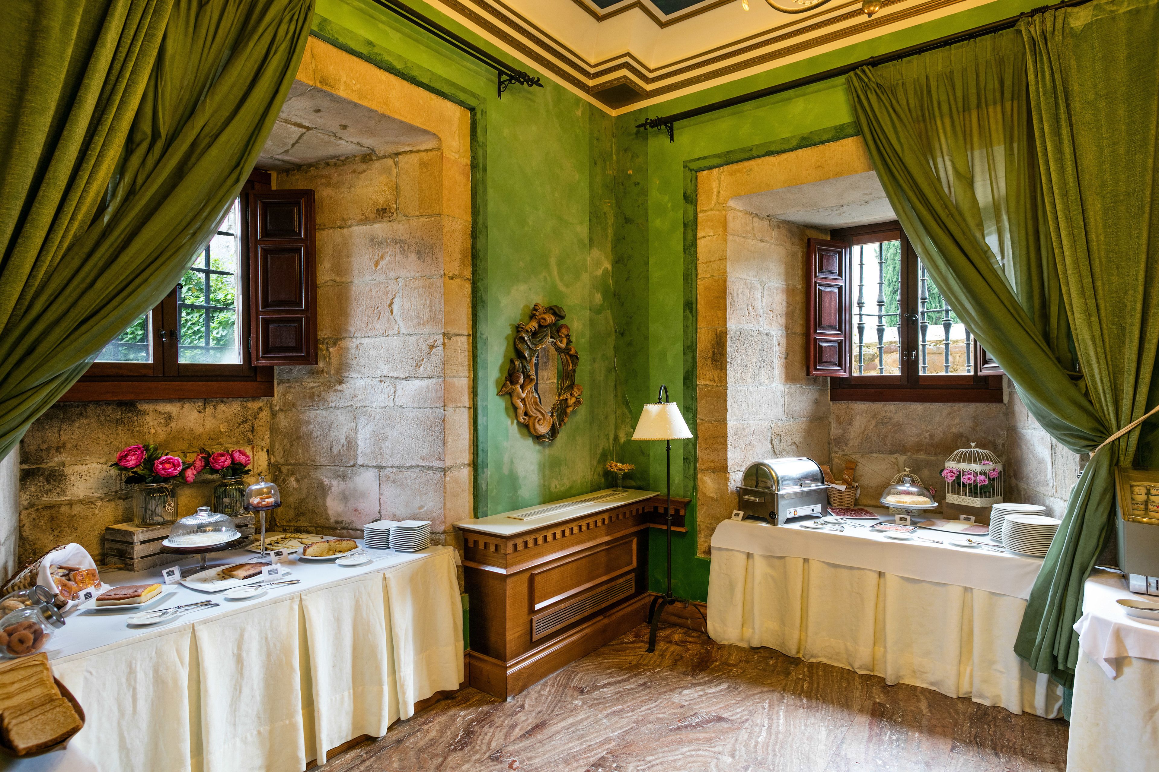Una habitación con una larga mesa dispuesta para el desayuno, un banco de madera y una lámpara.
