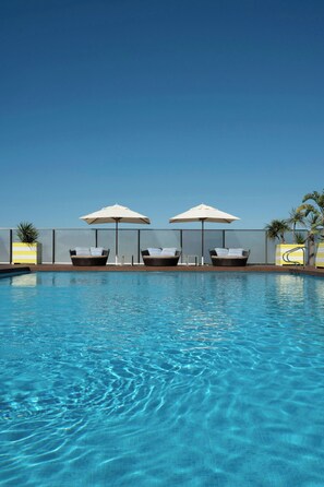 A swimming pool with lounge chairs and umbrellas. - Le Meridien Ra Beach Hotel & Spa (El Vendrell)