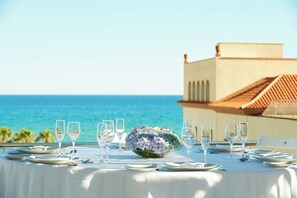 A table set for a meal with a view of the ocean. - Le Meridien Ra Beach Hotel & Spa (El Vendrell)