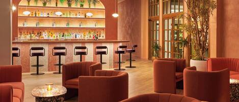 A bar area with multiple stools, a bar counter with shelves of bottles, and a large potted plant.