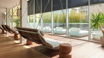 Een moderne loungehoek met rieten fauteuils en een groot raam met uitzicht op de omgeving.