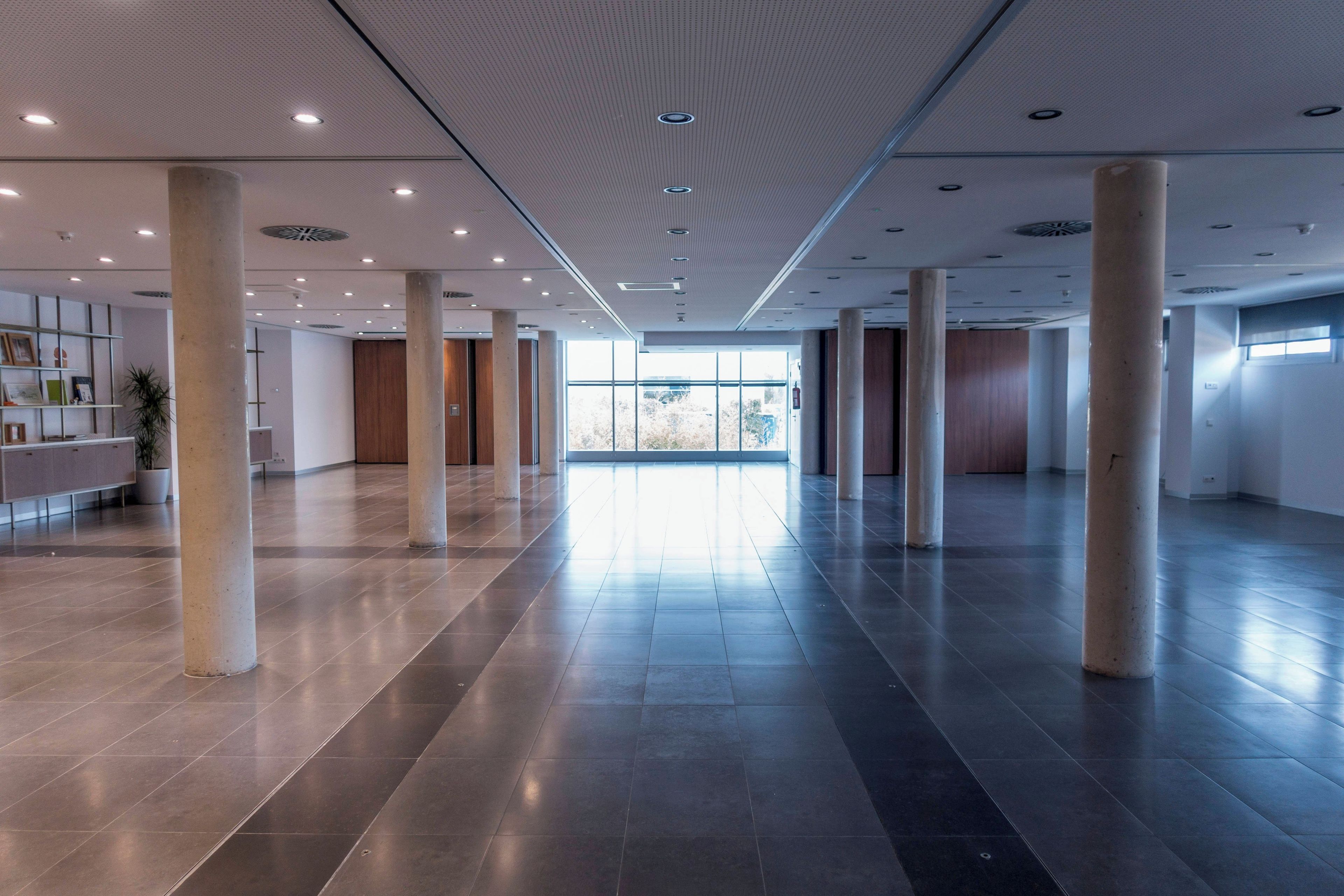 A spacious lobby with a high ceiling, large windows, and a modern design.