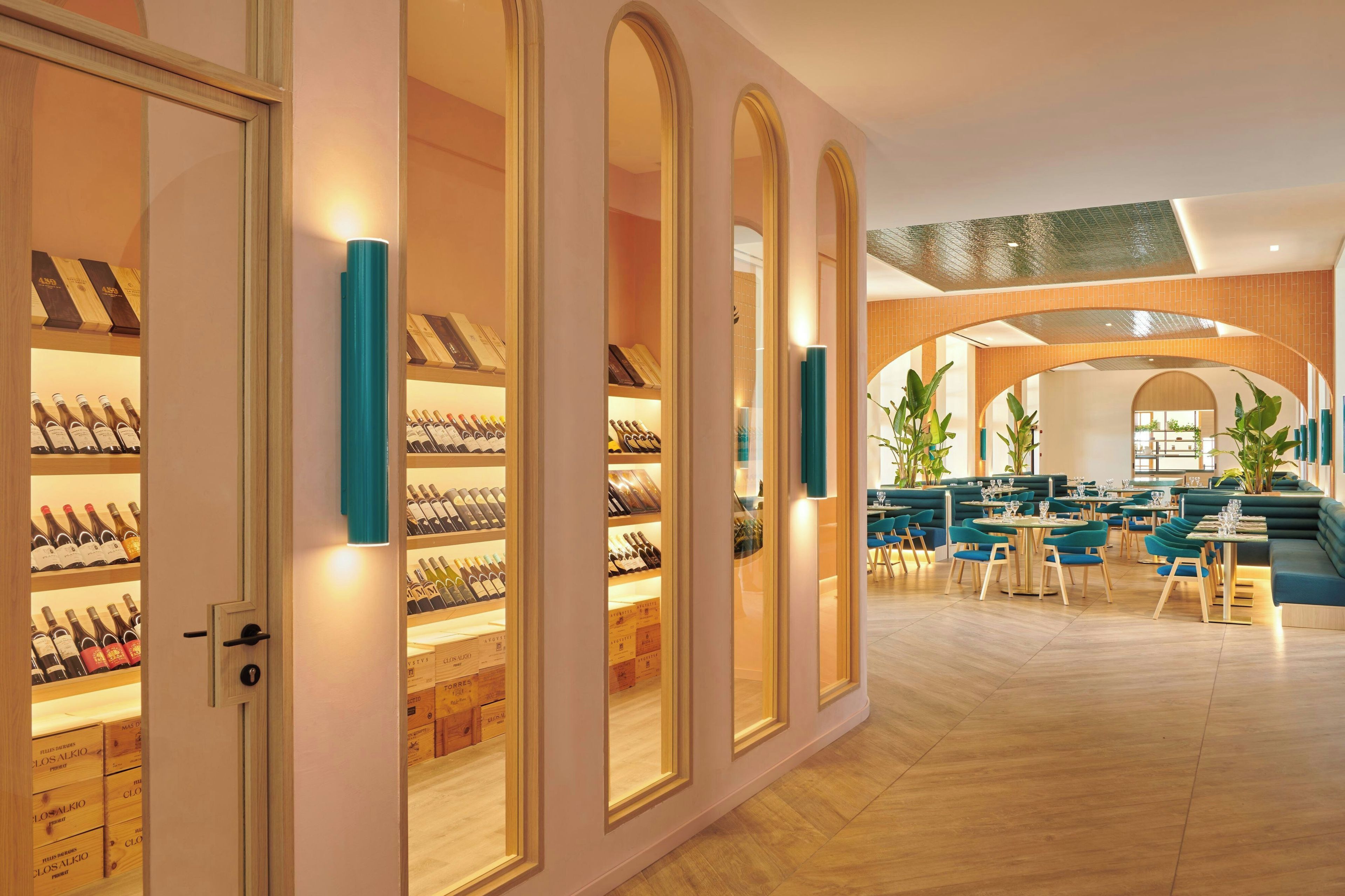 A spacious hotel lobby with a wine cellar, seating areas, and a modern architectural design.