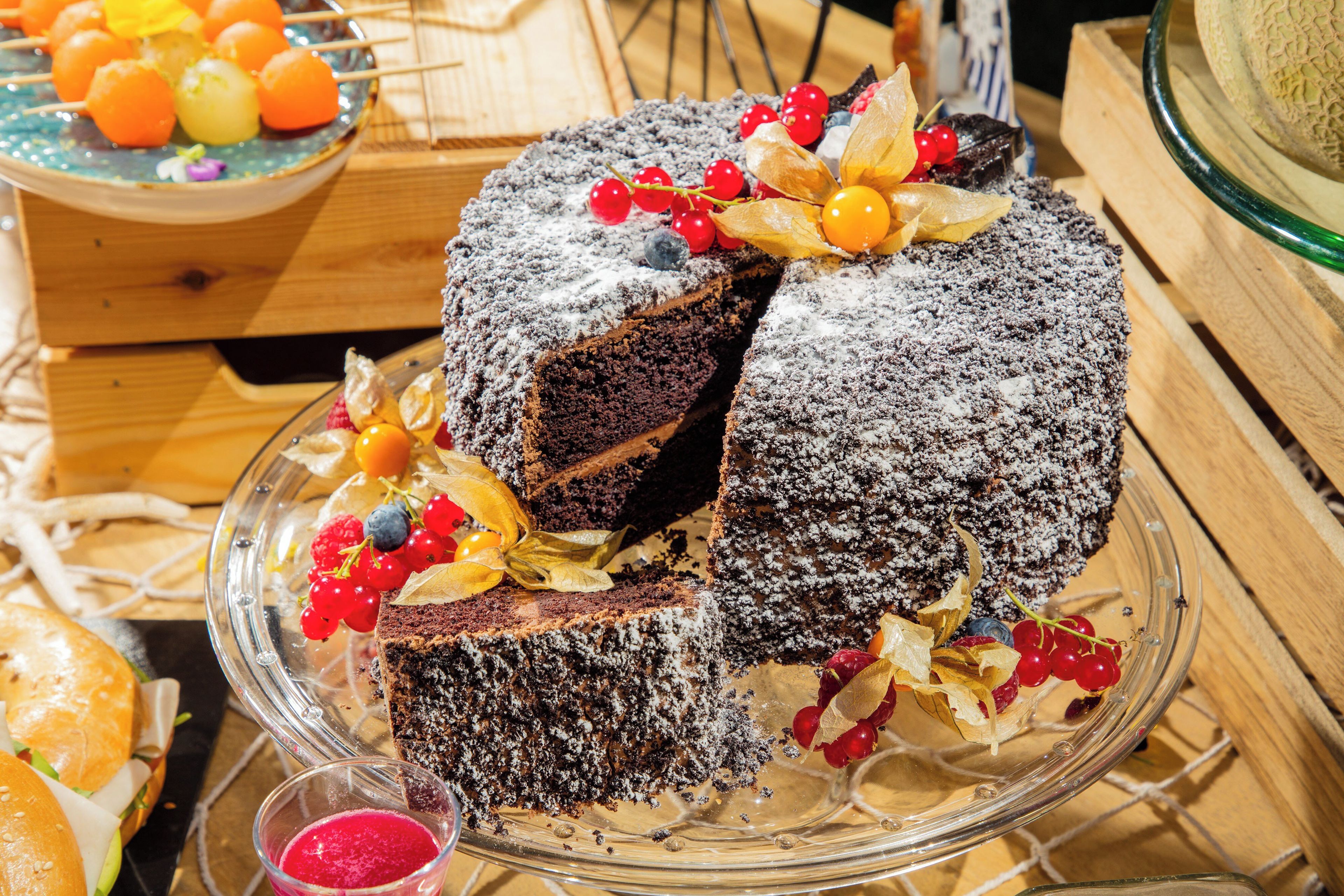 Taart met fruitdecoraties op een glazen plateau.