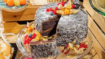 Taart met fruitdecoraties op een glazen plateau.