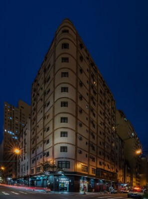 A multi-story hotel with a curved facade, multiple balconies, and a ground-level entrance with signage. - Real Castilha Hotel (São Paulo)