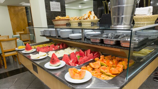 A buffet with various fruits and bread baskets. - Real Castilha Hotel (São Paulo)