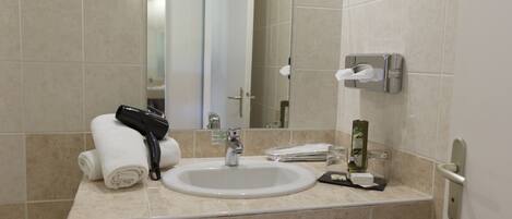 A bathroom with a sink, mirror, towel rack, and toiletries.