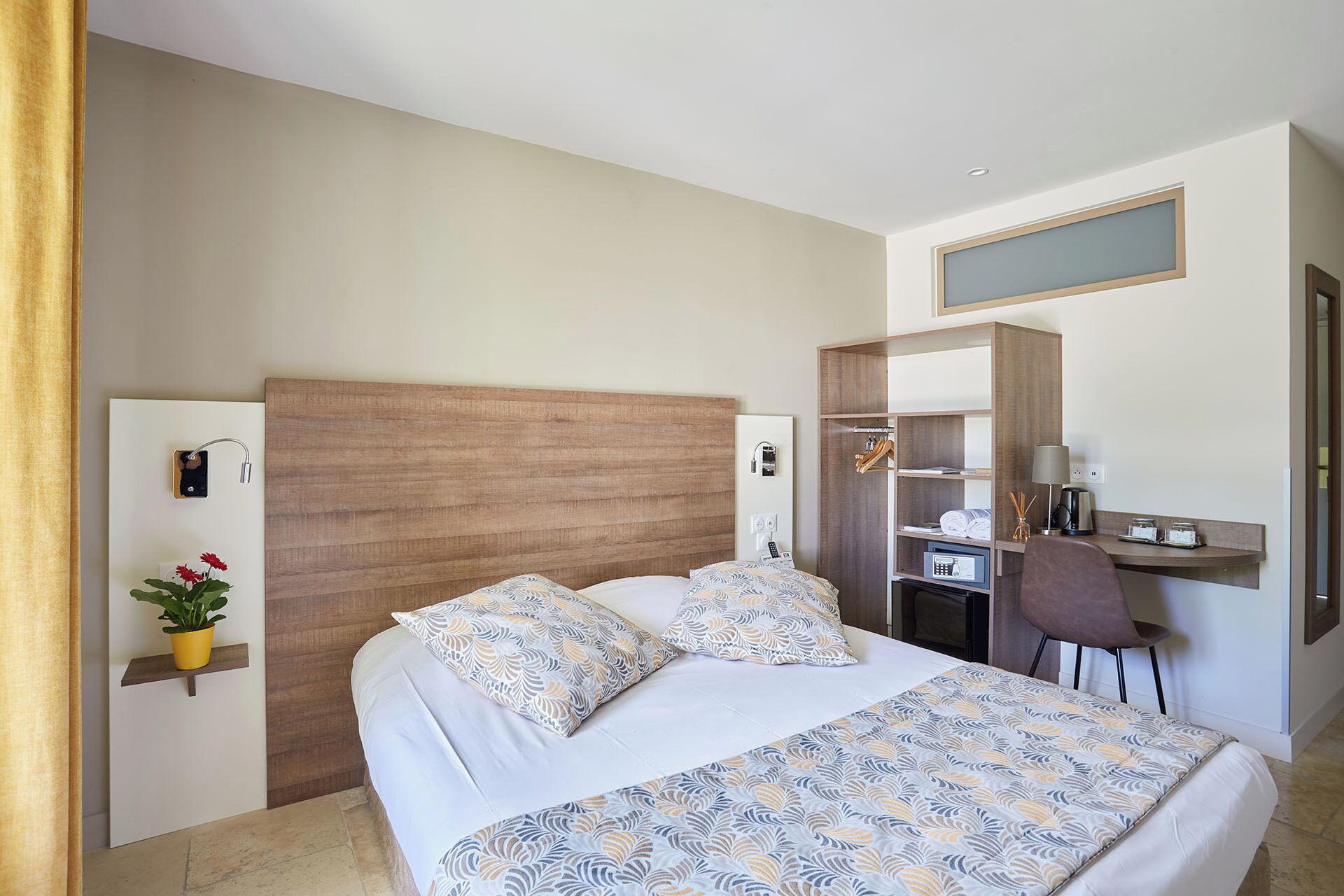 Ein Hotelzimmer mit einem großen Bett, einem Schreibtisch und einem Kleiderschrank.