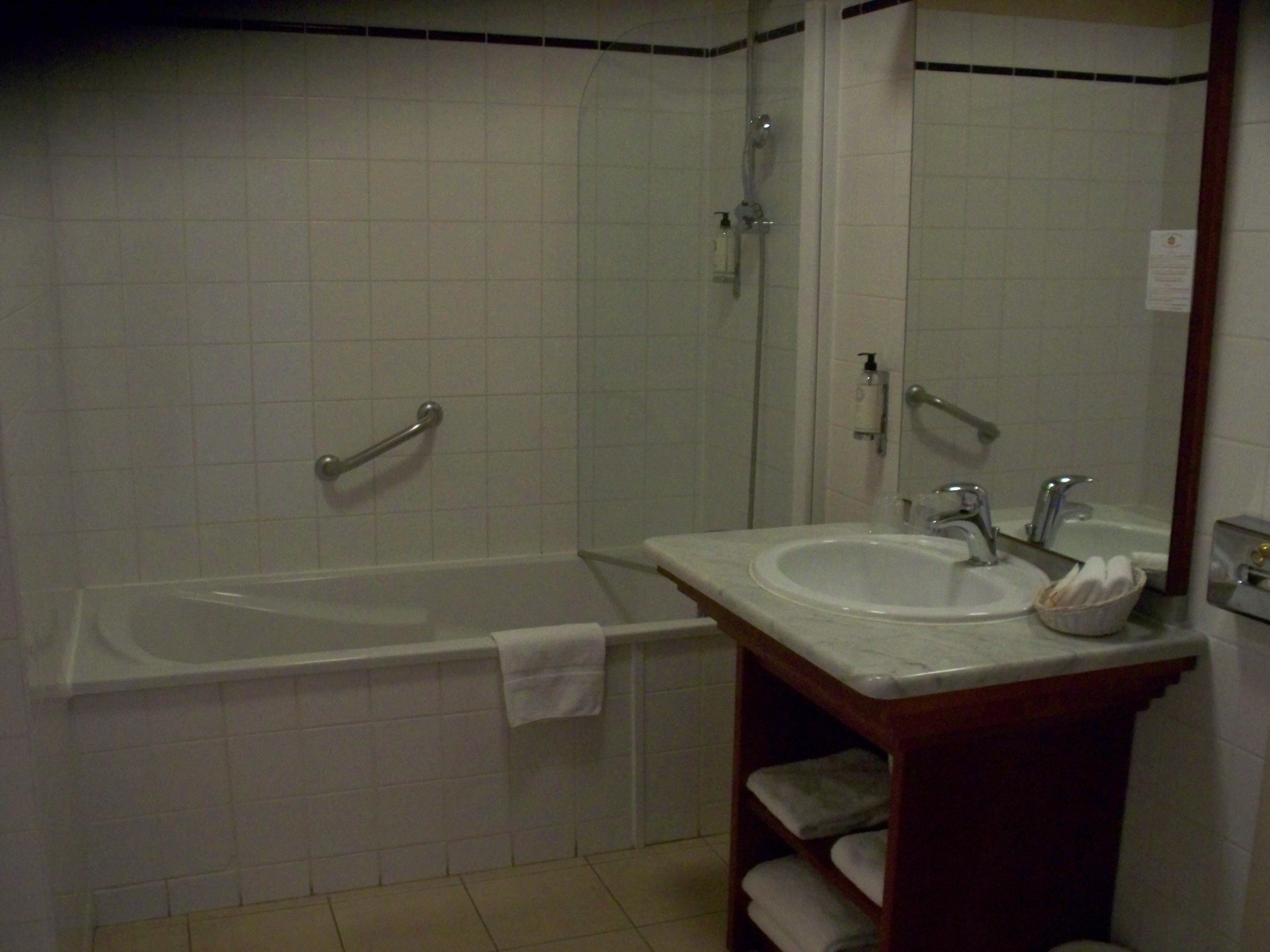 Une salle de bain avec une baignoire, un lavabo et un miroir.