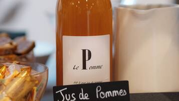 Una botella etiquetada como "Le Pomme" con un cartel que indica "Jus de pommes" y "Les Voeux du Franc Picaud".