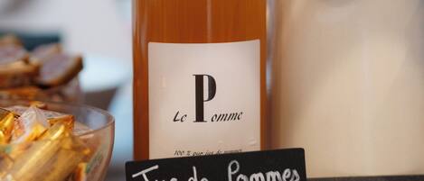 Una botella etiquetada como "Le Pomme" con un cartel que indica "Jus de pommes" y "Les Voeux du Franc Picaud".