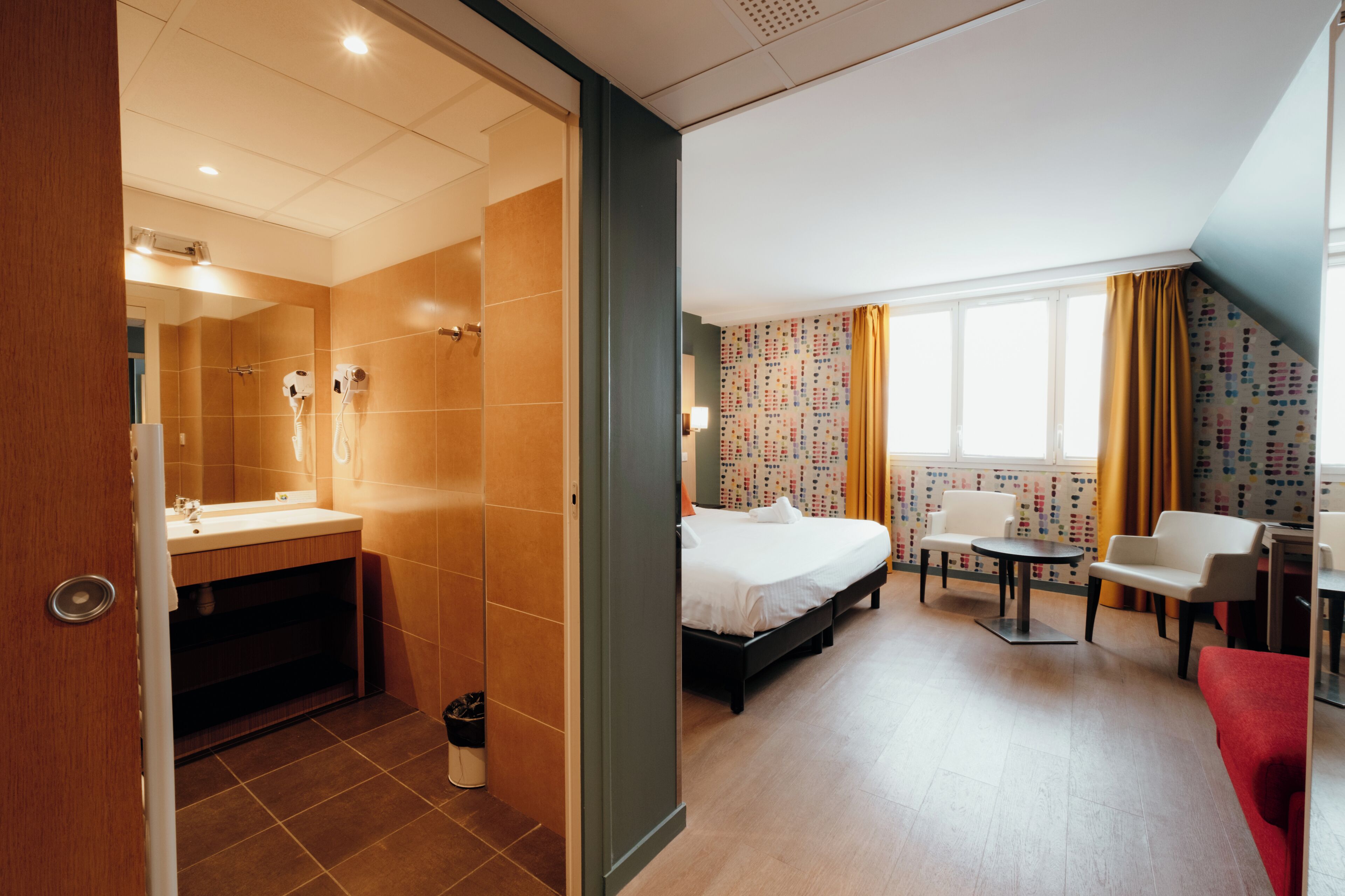 Een hotelkamer met een douche, een bed, een bureau en een stoel.
