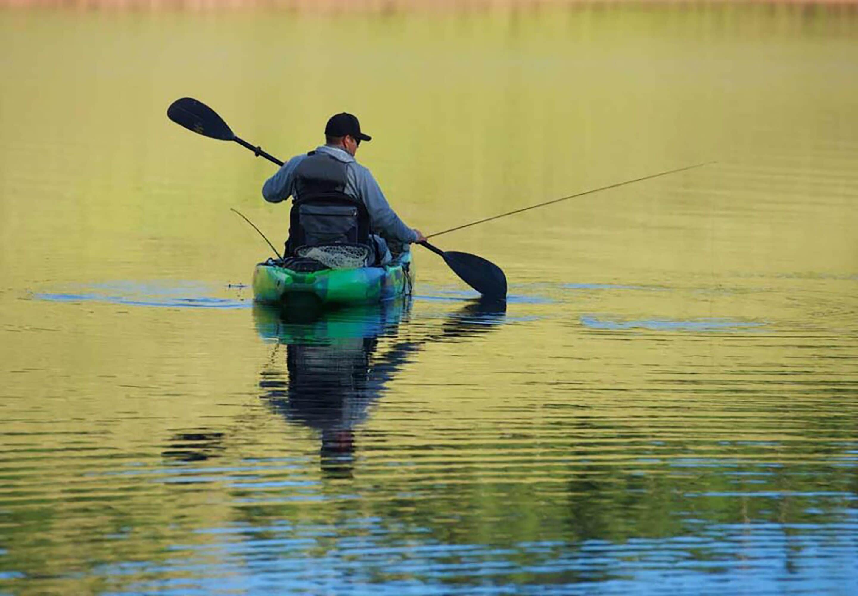 A person in a kayak on calm water.