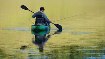 A person in a kayak on calm water.