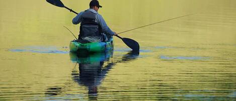 A person in a kayak on calm water.