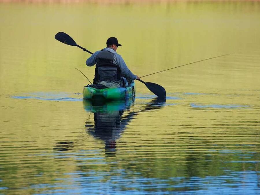 A person in a kayak on calm water.