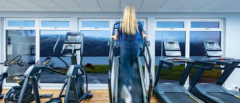 A gym with treadmills, elliptical machines, and stationary bikes.
