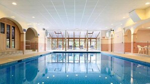 An indoor swimming pool with clear glass walls, wooden arches, and a tiled floor. - Loch Rannoch Hotel and Spa (Pitlochry)