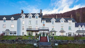 A large, multi-story building with a symmetrical facade, multiple windows, and a central entrance with steps leading up to it. - Loch Rannoch Hotel and Spa (Pitlochry)