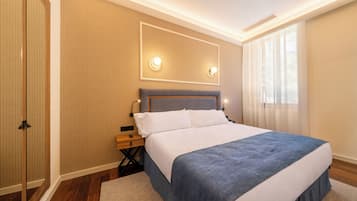 Quarto de hotel moderno com uma cama grande, paredes de painel de madeira, um espelho e uma janela com cortinas.
