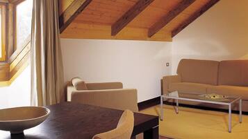 Una sala acogedora con un sofá, una mesa de centro y una mesa de comedor con sillas.