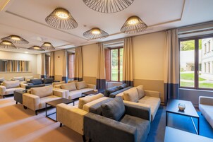 A hotel lobby with multiple sofas, a coffee table, and pendant lighting.