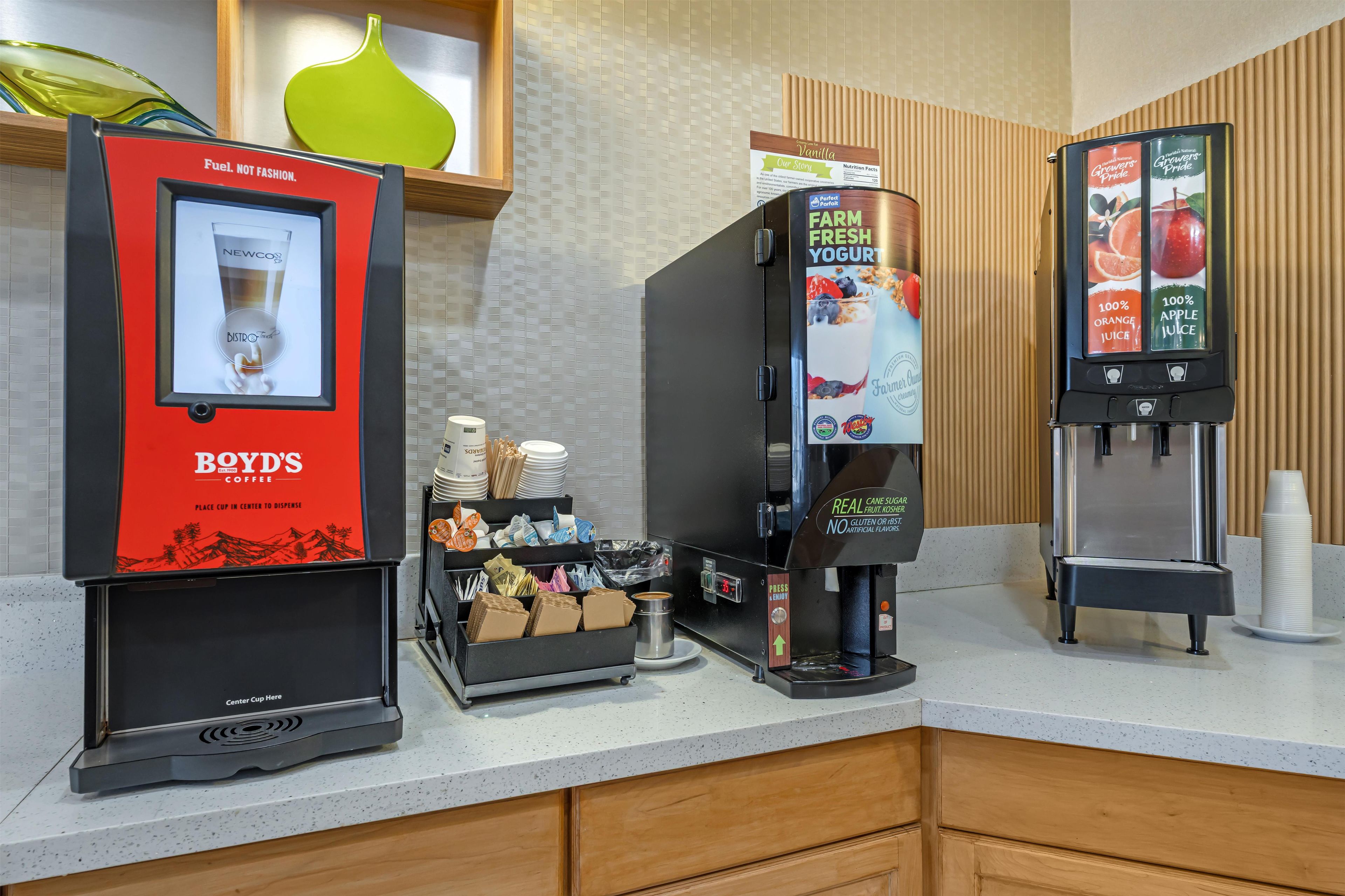 A coffee station with a coffee machine, a beverage dispenser, and a cup holder.