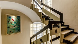 A staircase with a modern design, featuring a glass art piece on the wall. - Sacromonte Hotel (Granada)