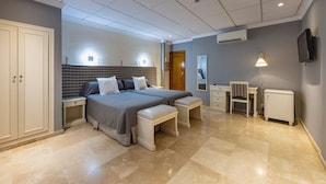 A modern bedroom with a large bed, two bedside tables, a desk, and a chair. - Sacromonte Hotel (Granada)