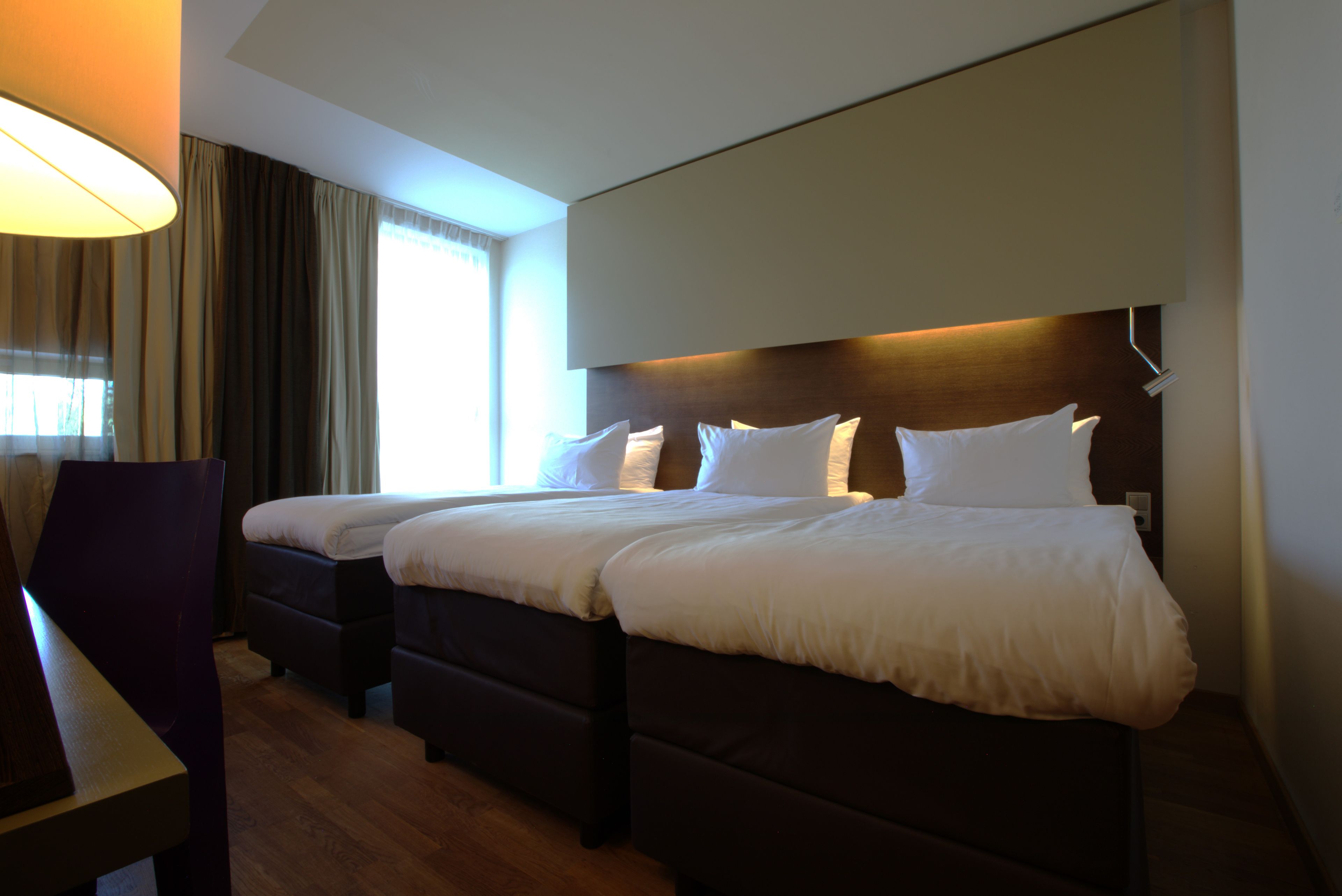 Una habitación de hotel con una cama grande, un escritorio y una silla.