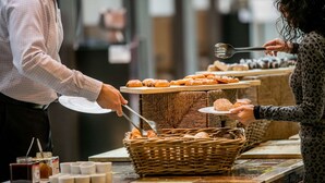 A buffet setup with various baked goods and a wicker basket on a counter. - Hotel Artemis Amsterdam (Amsterdam)