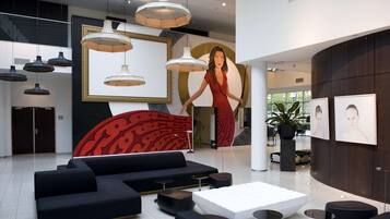 A modern lobby with black sofas, a white coffee table, and pendant lighting.