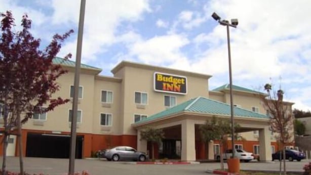 A Budget Inn hotel with a parking lot, a covered entrance, and a signboard. - Budget Inn San Leandro (San Leandro)