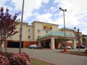 A Budget Inn hotel with a parking lot, a covered entrance, and a signboard. - Budget Inn San Leandro (San Leandro)