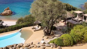 Un complexe hôtelier doté d’une piscine, d’un espace de plage et offrant une vue sur la mer et les montagnes.