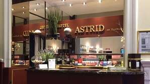 A hotel reception area with a clock, a globe, and a sign reading "HOTEL ASTRID". - Astrid Hotel am Kurfürstendamm (Berlin)