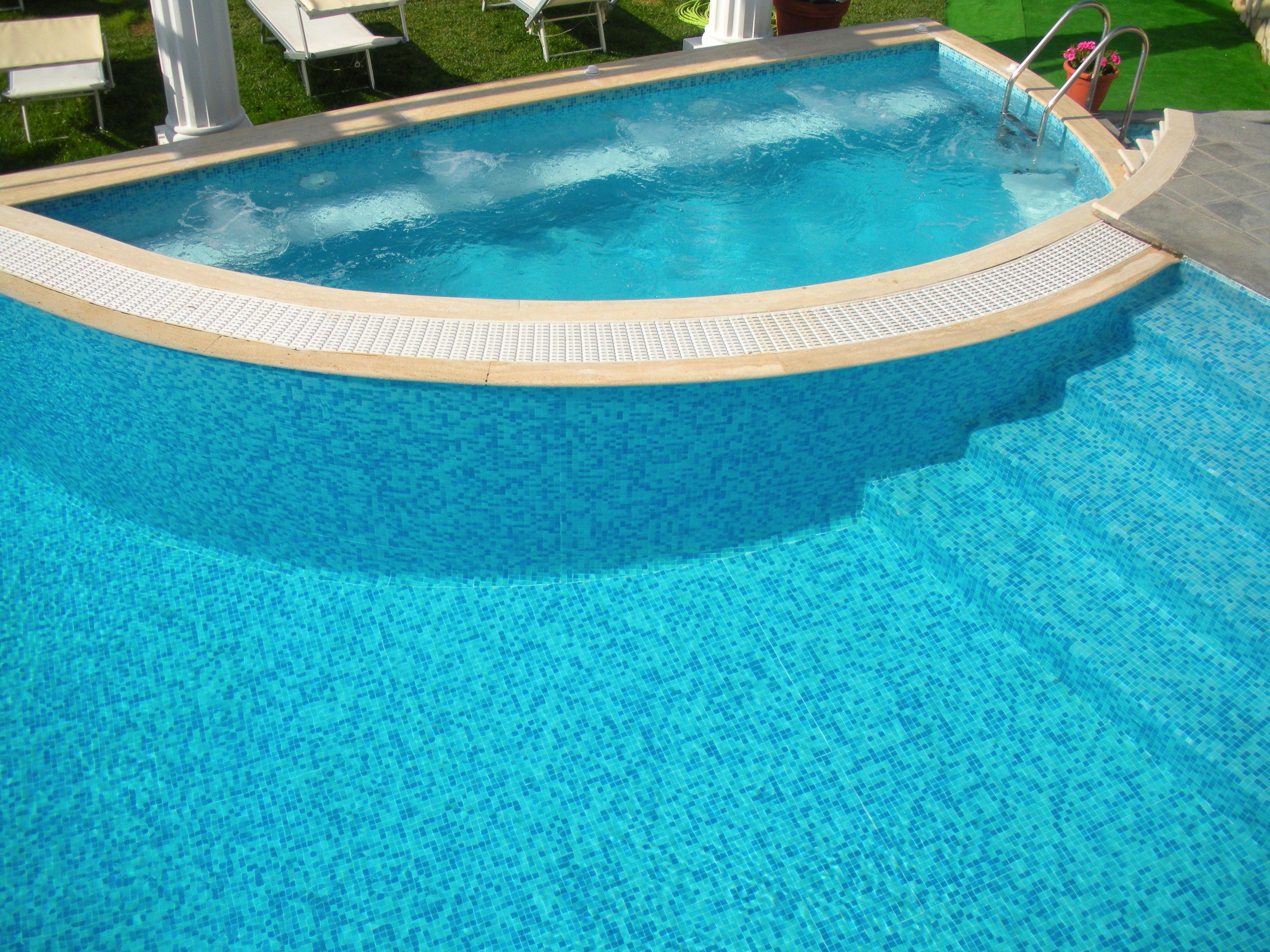 A swimming pool with a tiled edge and a ladder leading into the water.