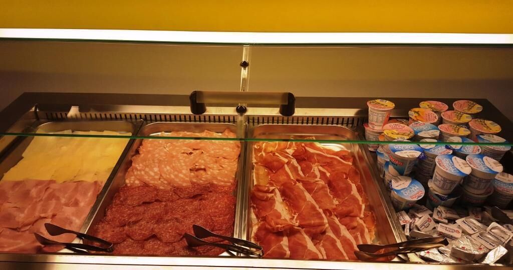 Eine Feinkosttheke mit verschiedenen Fleischwaren und verpackten Produkten.
