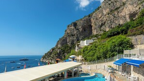 A pool area with a view of the sea and a rocky cliff. - Hotel Weber Ambassador (Capri)