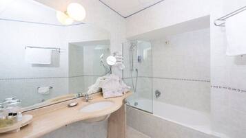 Une salle de bain moderne avec un grand miroir, un lavabo, une douche et une baignoire.