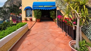 A yellow building with "HOTEL WEBER" signage, a blue awning, and potted plants. - Hotel Weber Ambassador (Capri)