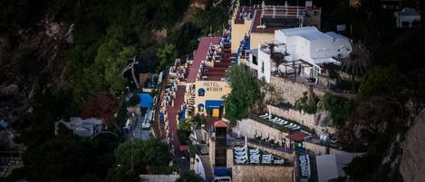 Vista aérea del Hotel Weber con piscina, varios pisos y un muro de piedra.